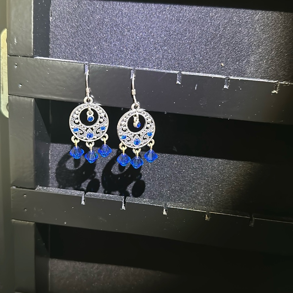 Silver dangle earrings with blue stone accents